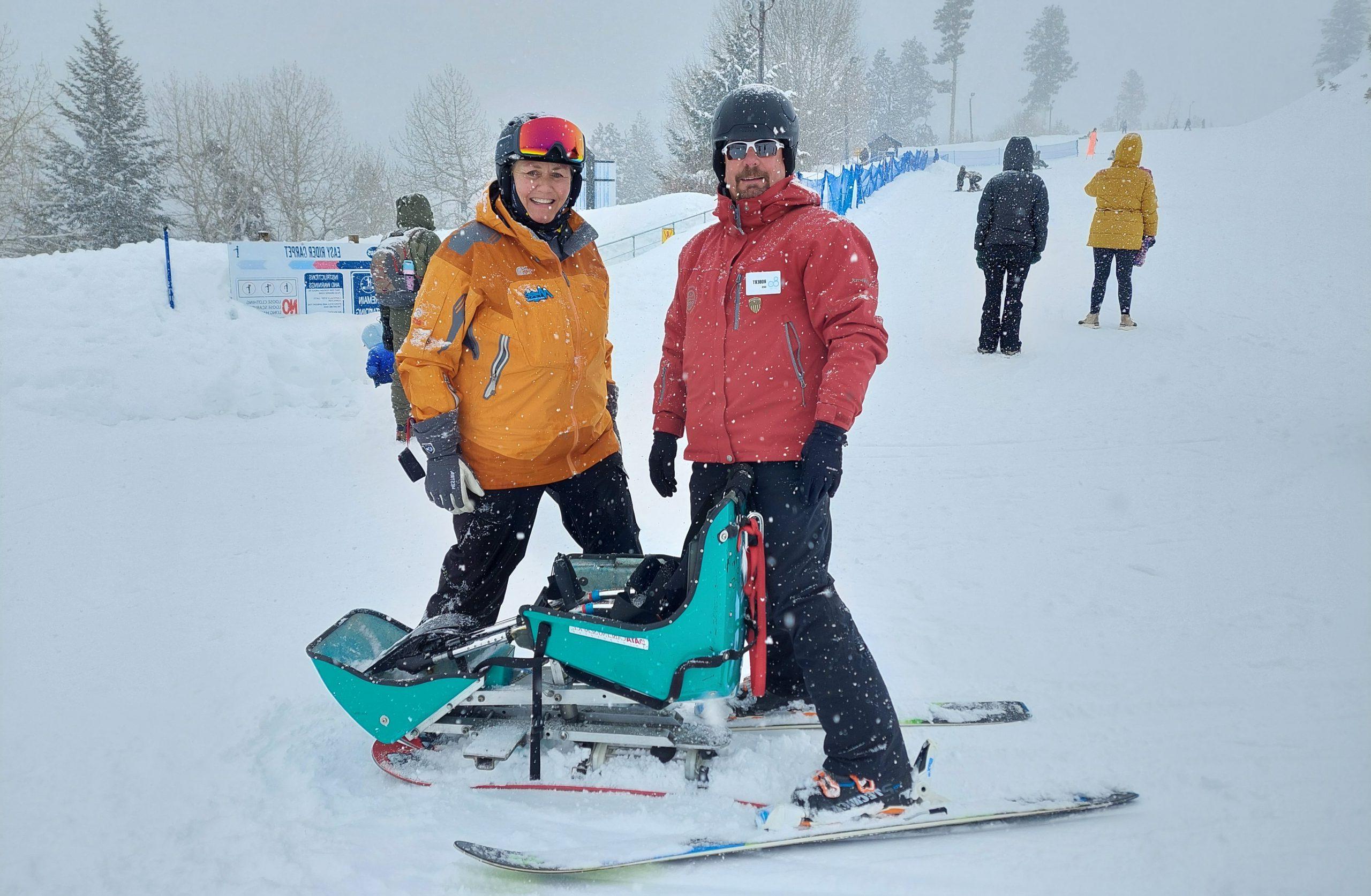 员工罗伯特·沃尔特斯和一名手持自适应滑雪板的女子